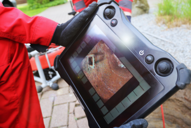 Professional plumbers inspecting the drain using a drain camera.